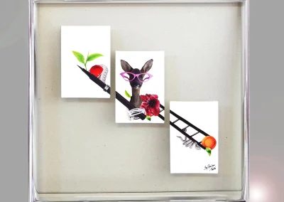 Trois illustrations disposées en diagonale sur verre, dans un cadre caisse argenté