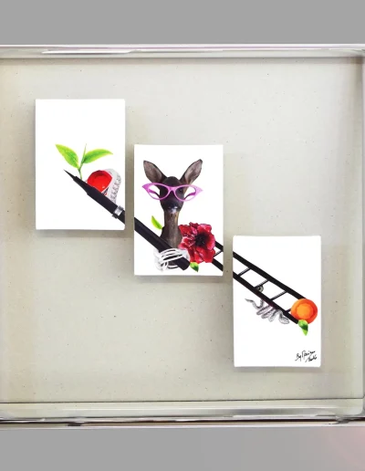 Trois illustrations disposées en diagonale sur verre, dans un cadre caisse argenté